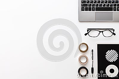 Laptop keyboard, a pen, glasses, a notebook with wheels and three tapes Stock Photo