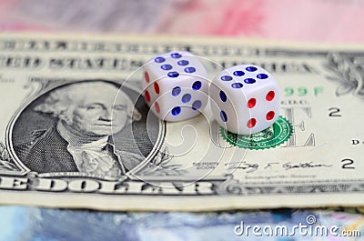 White dice are on a dollar bill of US dollars. The concept of gambling with rates in monetary unit Stock Photo