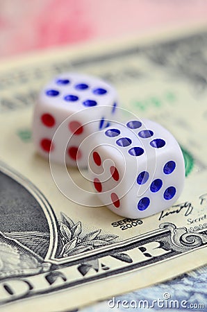 White dice are on a dollar bill of US dollars. The concept of gambling with rates in monetary unit Stock Photo