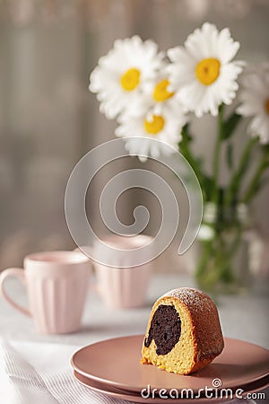 Round cupcake with a hole on a white dish, sprinkled with powdered sugar Stock Photo