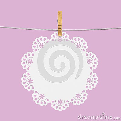White doily hanging on rope with wooden clothespin Stock Photo