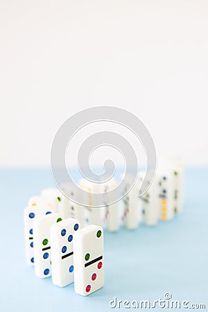 White dominoes with brightly colored dots lined up in a curving series Stock Photo