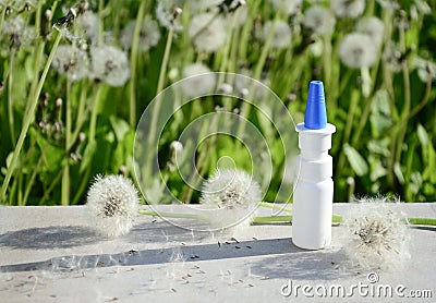 White dropper bottle mock up and dandelions on gray background with shadows with copy space. Concept of allergy treatment. Nose Stock Photo