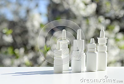 White dropper bottles, nose spray on background of spring flowering trees with copy space. Concept of allergy treatment. Nose Stock Photo