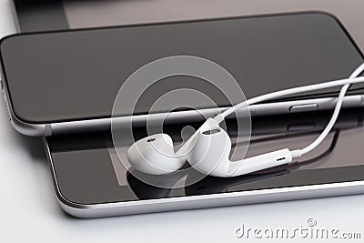 White earphones on tablet and phone Stock Photo