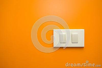 White electricity switch on orange wall background Stock Photo