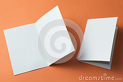 White empty brochure on orange background to replace your design. Mockup Stock Photo