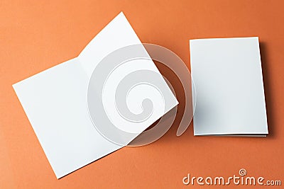 White empty brochure on orange background to replace your design. Mockup Stock Photo