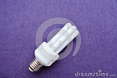 White energy-saving fluorescent light bulb with four tubes, with a silver cap Stock Photo