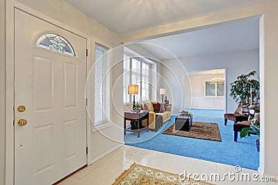 White enterance door. Hallway connected to cozy modern living room Stock Photo