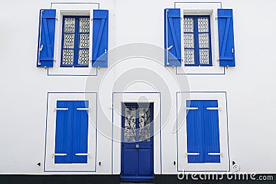 White facade house with blue windows and shutters, open and closed shutters Stock Photo