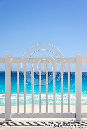 White fence and blue ocean on a tropical beach Stock Photo