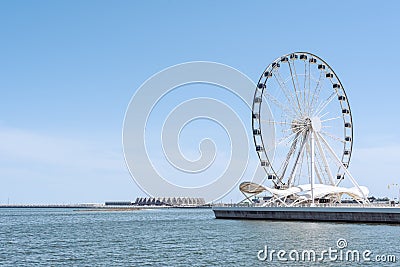 White Ferris wheel attraction on seacoast Editorial Stock Photo