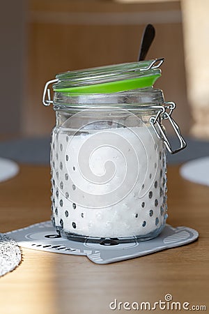 White fine sugar in retro large glass jar on table Stock Photo