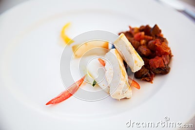 White fish with stewed eggplant garnish on plate Stock Photo