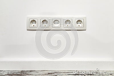 White five-way wall power socket on white wall Stock Photo