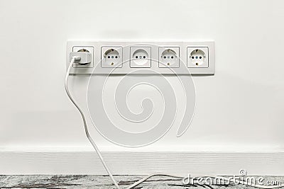 White five-way wall power socket on white wall Stock Photo