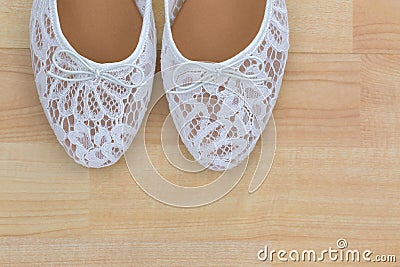 White floral lace ballet flat slip on shoes on wooden background Stock Photo