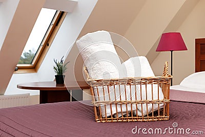 White fluffy towels rolled into a roll in a wicker basket in the hotel room Stock Photo