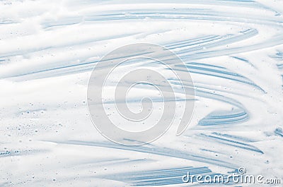 White foam texture close up on blue background. Soapy substance with bubbles backdrop. Creamy grainy macro. Shower gel, washing Stock Photo