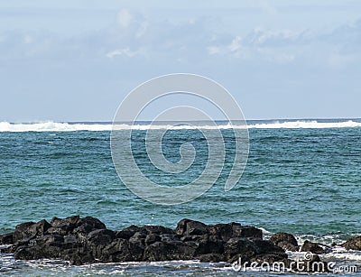 White foamy wave in distance coming in from aqua sea Stock Photo