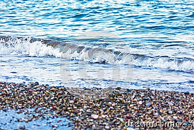 The white foamy waves on the pebble stones of the Mediterranean in Konyaalti Beach. Stock Photo