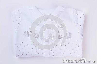 White folded baby pajamas with cartoon images. Stock Photo