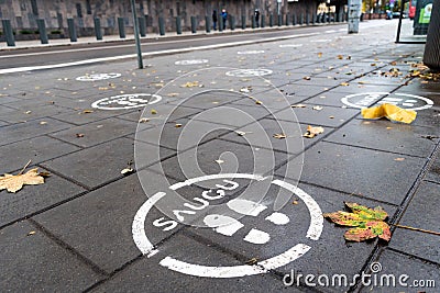 White footprints marked sign on the footpath at the bus stop Stock Photo