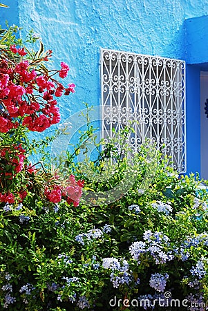 White forged patterned lattice and flowering plants Stock Photo