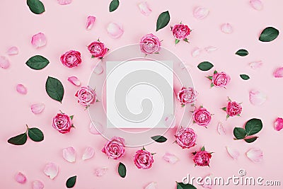 White frame blank, pink rose flowers and petals for spa or wedding mockup on pastel background top view. Beautiful floral pattern. Stock Photo