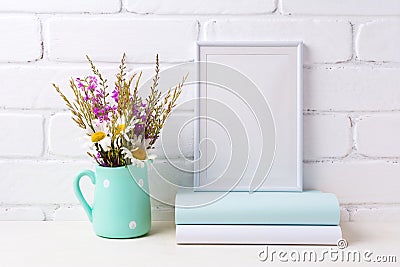 White frame mockup with chamomile and purple flowers in mint green pitcher and books Stock Photo