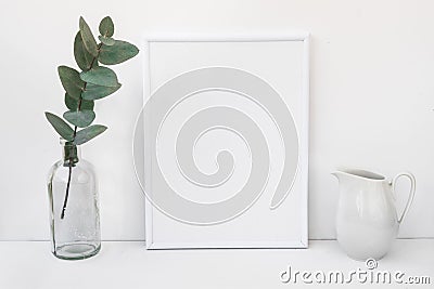White frame mockup, eucalyptus branch in glass bottle, pitcher, styled minimalist clean image Stock Photo