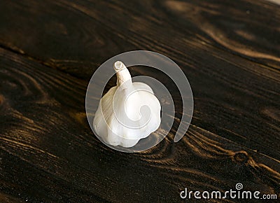White garlic head on a dark brown wooden background. Stock Photo
