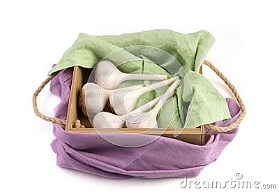 White garlic isolated on a white background, side view, beautifully packaged in a wooden box with colored napkins. Stock Photo