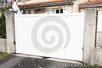 White gate large portal with double door panel blades in city suburbs house street Stock Photo
