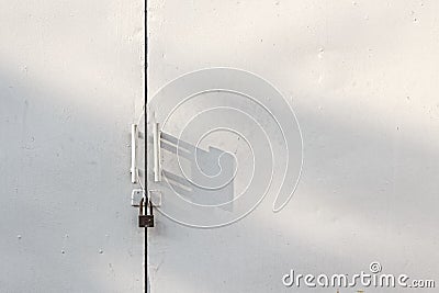 White gate locked with rusted padlock Stock Photo