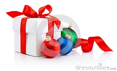 White gift box tied red ribbon bow and Christmas colored baubles Isolated on white background Stock Photo