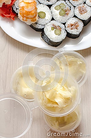 White ginger in plastic disposable jars and rolls. Japanese food delivery home. Vertical photo Stock Photo