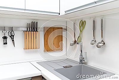 White glossy kitchen interior design with hanging utensils Stock Photo