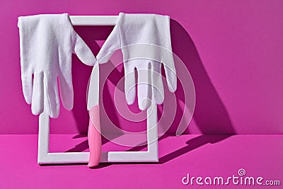 White gloves and a pink ceramic knife on the photo frame. The concept of a better chef. Award Stock Photo