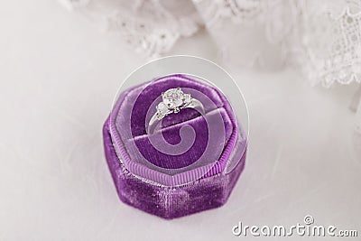 White golden wedding ring with diamonds in purple vintage velvet Stock Photo