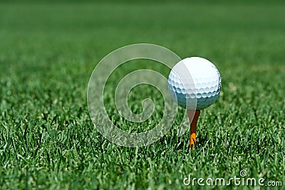 White golf ball on a orange tee Stock Photo