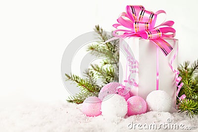 White greeting card with copy space for christmas or new year with a wrapped gift, fir branches and pink ball on snow Stock Photo