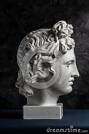 White gypsum copy of ancient statue of Apollo God of Sun head for artists on a dark textured background. Renaissance Editorial Stock Photo