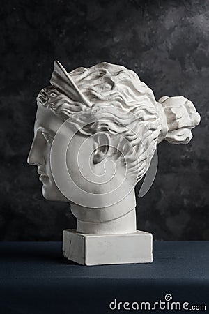 Gypsum copy of ancient statue Diana head on a dark textured background. Plaster sculpture woman face. Stock Photo