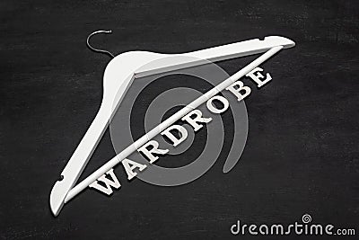 White hangers and word from letters Wardrobe on black background. Sale Stock Photo