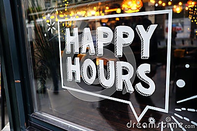 White `happy hours` sign on restaurant window with beautiful bokeh balls in the background Stock Photo