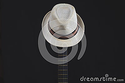 White hat hangs on the guitar fretboard. acoustic musical instrument. strings on the guitar neck Stock Photo