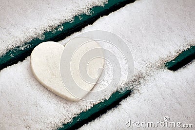 White heart on snow-covered bench. Valentines day Stock Photo