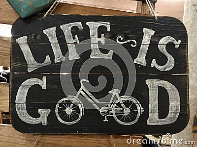 White inscription Life is good on an old wooden black board with a bicycle Stock Photo